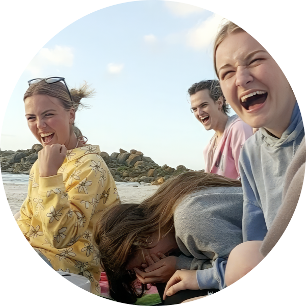 Friends hang out and laugh on the beach.