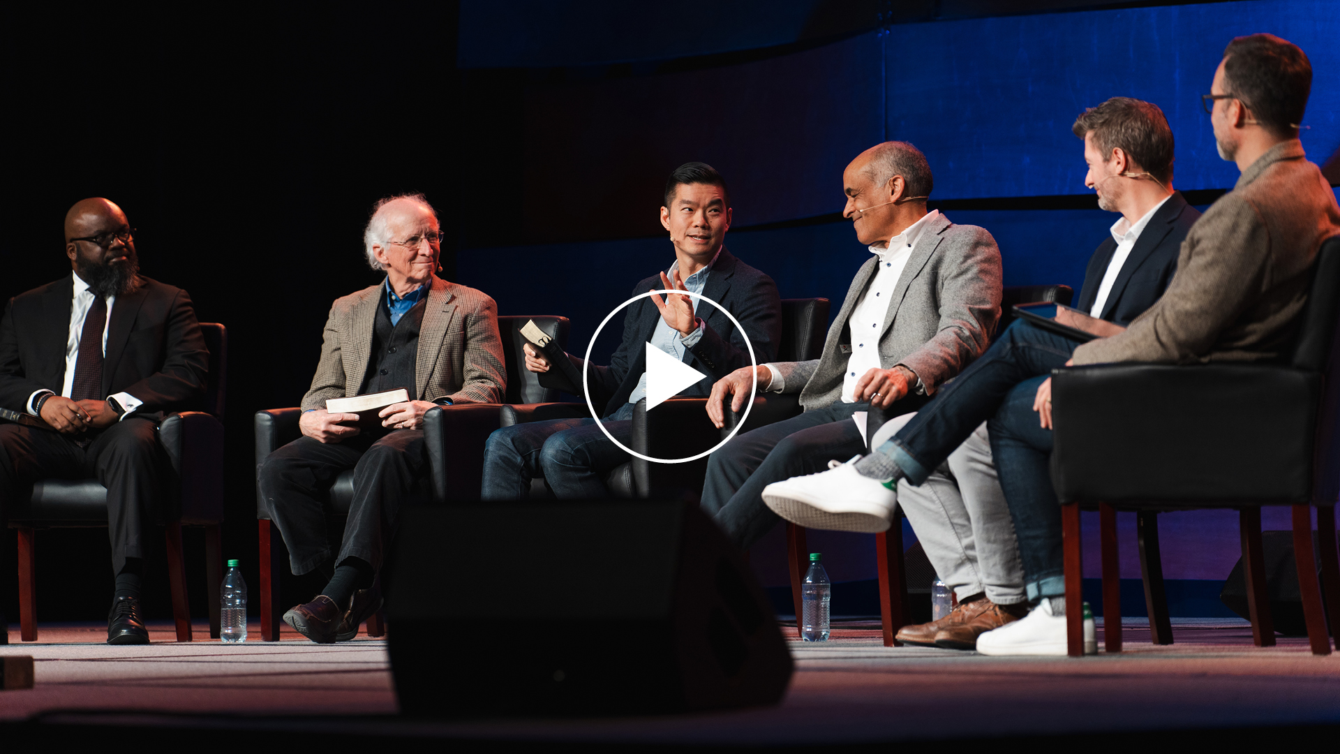 Several men sit on a stage discussing various topics at the Serious Joy conference for pastors.