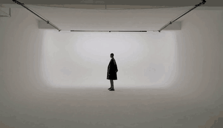 A model in a white studio as the flash fires, generated by HeyGen Video