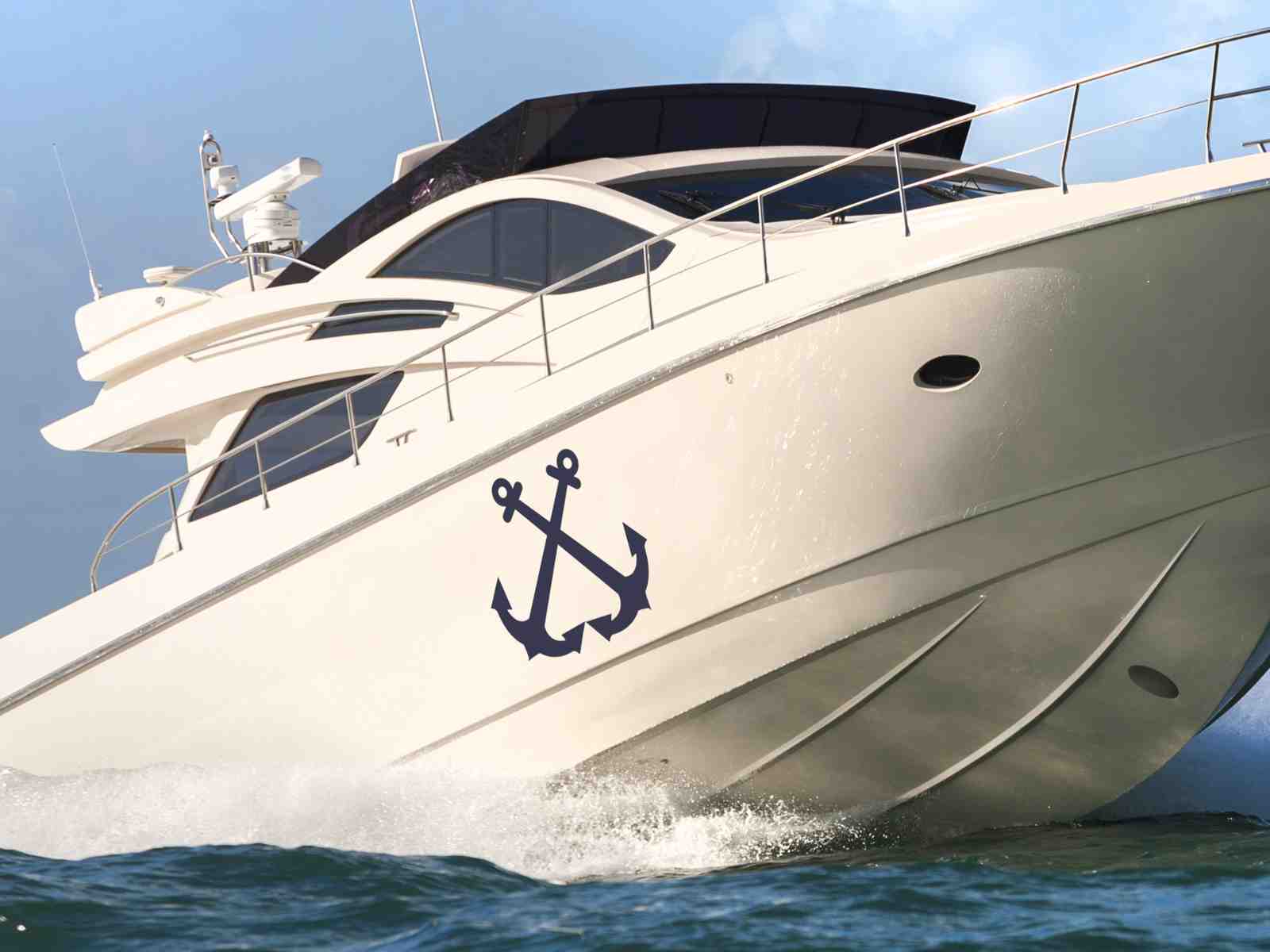 Navy blue crossed anchor boat decal applied to the hull of a white yacht for a custom nautical look.