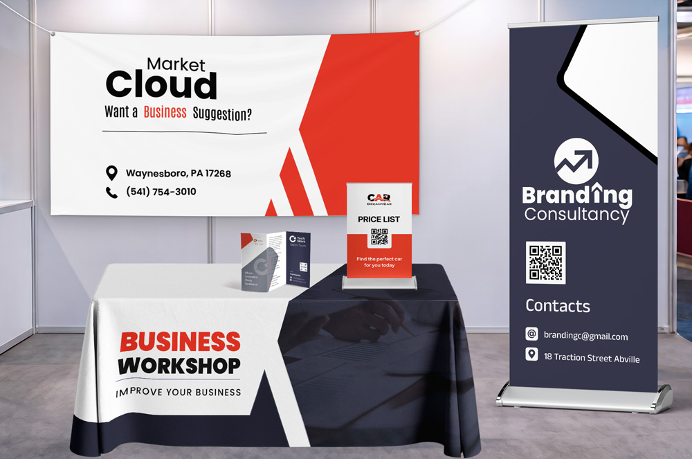 Trade show booth display featuring a custom backdrop banner, retractable banner stand, branded table cover, tabletop sign holder, and brochures with coordinated business branding in red, white, black, and gray.
