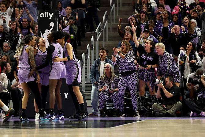 Golden State Valkyries players celebrate on the court as fans and team staff cheer from the sidelines