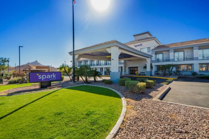 Exterior of a Hilton hotel with a blue sky and a green lawn
