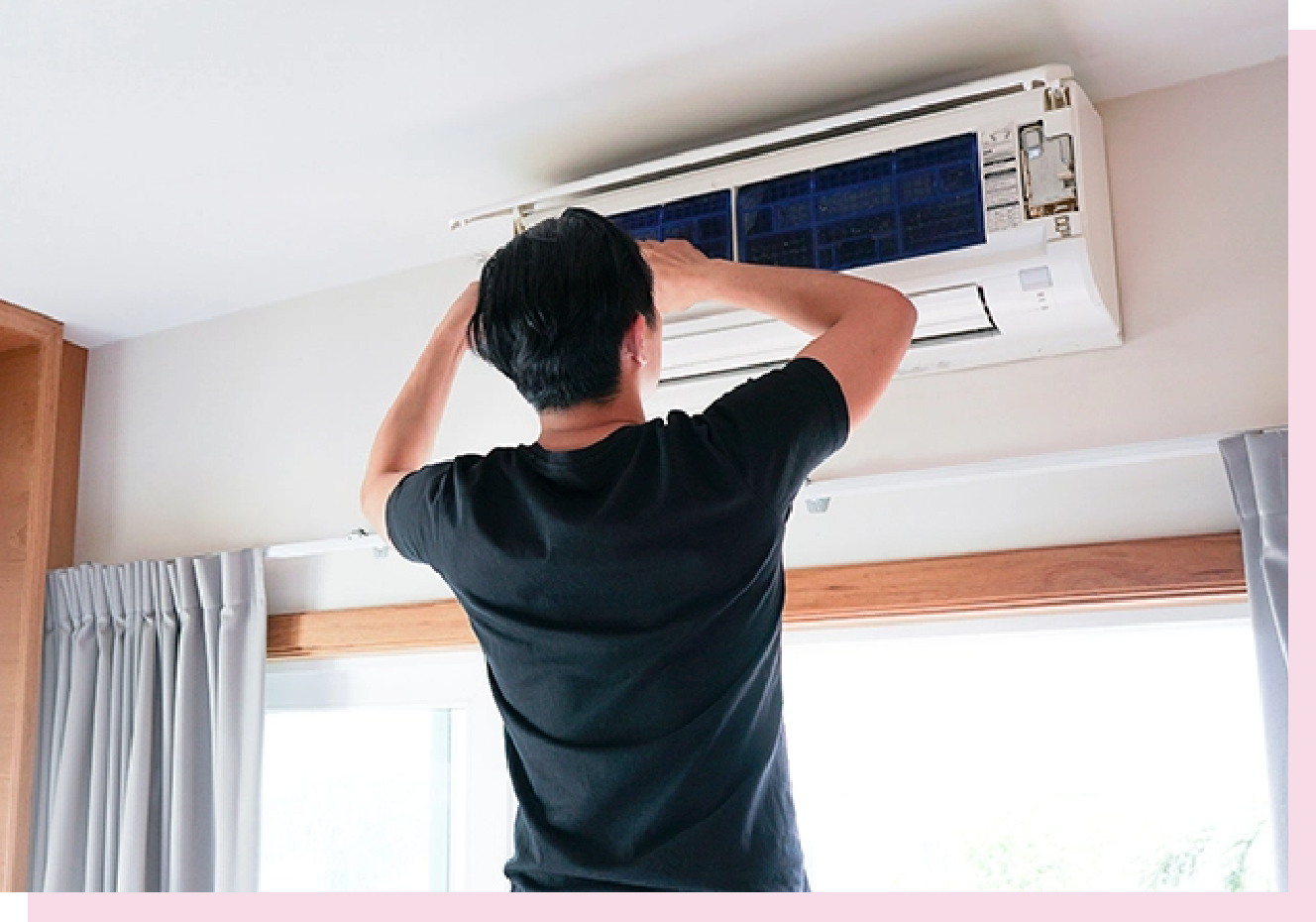 image of a man fixing a mini-split AC unit