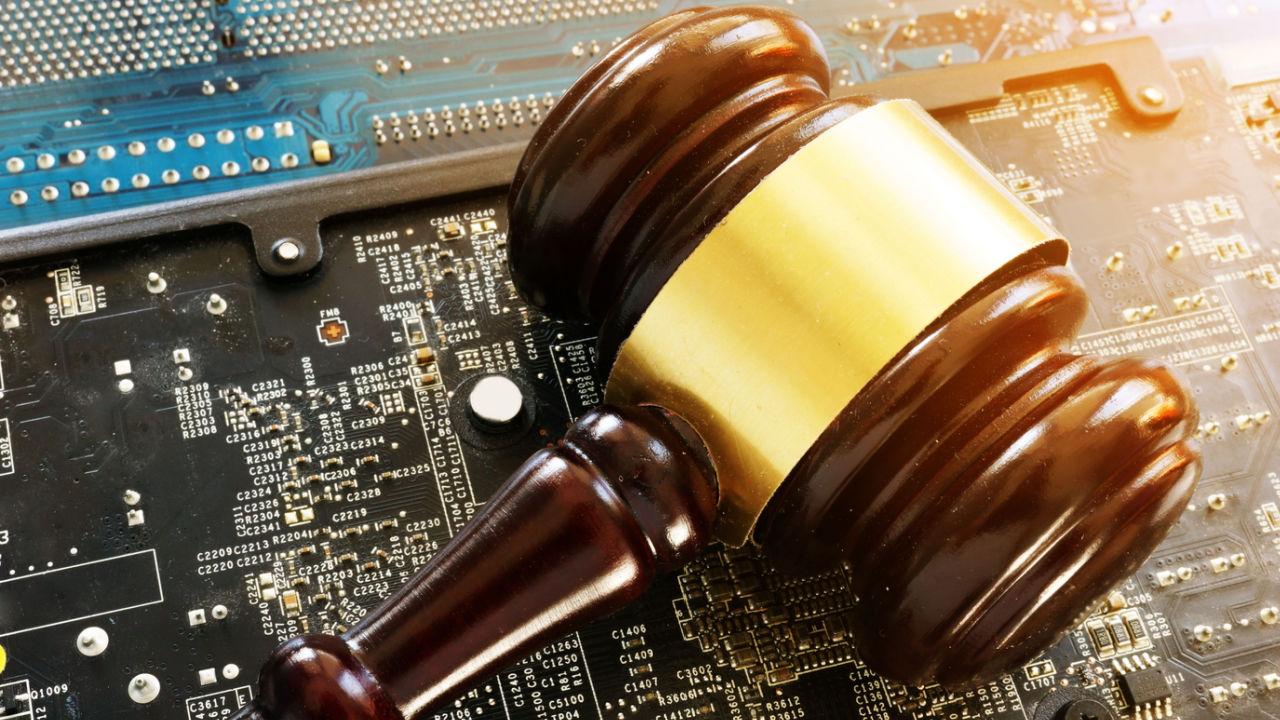 Judge's gavel on circuit board; Robert Kiyosaki warns of regulations, buys bitcoin.